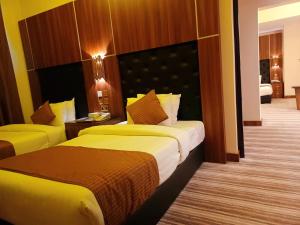 Royal Qatar Hotel في الدوحة: غرفه فندقيه سريرين في غرفه