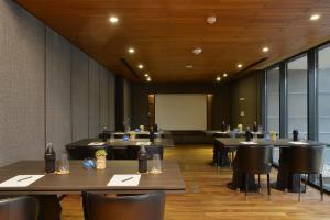 Akyra Manor Chiang Mai SHA Extra Plus في شيانغ ماي: قاعة اجتماعات مع طاولات وكراسي وطاولة بيضاء