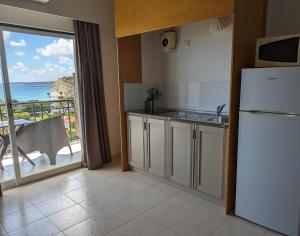 a kitchen with a refrigerator and a view of the ocean at Vivenda Solmar in Lagos