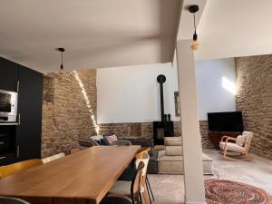 a living room with a wooden table and a couch at La grange - Grande longère à moins de 30 minutes des plages in Plumelec