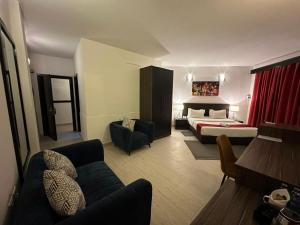 Habitación de hotel con cama y sofá en Hotel Belle Vie en Kinshasa