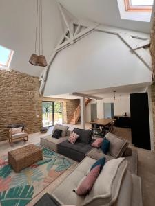a large living room with a couch and a brick wall at La grange - Grande longère à moins de 30 minutes des plages in Plumelec