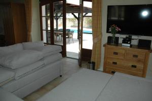 a living room with a couch and a tv at Nandolle Farmhouse in Nanteuil-de-Bourzac
