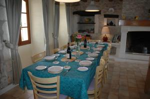 a long table with chairs and a blue table cloth at Nandolle Farmhouse in Nanteuil-de-Bourzac