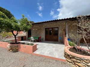 a stone house with a patio with a table and a tree at Residence Melograno in Capoliveri