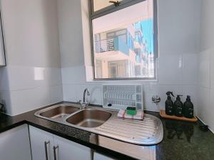 a kitchen counter with a sink and a window at The Waves in Muizenberg