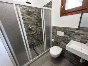a bathroom with a shower and a toilet and a sink at Residence Melograno in Capoliveri