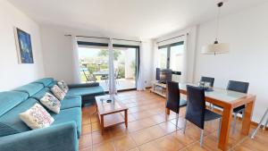 Una sala de estar con un sofá azul y una mesa. en Amapola, en L'Ampolla