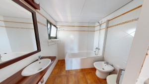 Un baño con lavabo, inodoro y bañera. en Amapola, en L'Ampolla 8 fotos más
