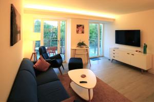 uma sala de estar com um sofá e uma televisão em FeWo Prora - room-of-light em Binz