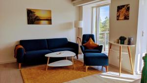 un soggiorno con divano blu e tavolo di FeWo Prora - room-of-light a Binz