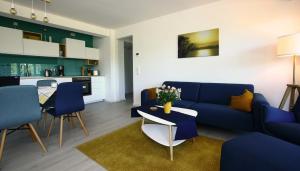 ein Wohnzimmer mit einem blauen Sofa und einem Tisch in der Unterkunft FeWo Prora - room-of-light in Binz