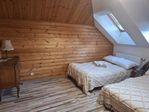 ein Schlafzimmer mit einem Bett und einer Holzwand in der Unterkunft Svirnelis in Medsėdžių