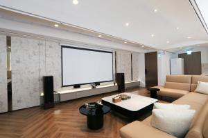 a living room with a couch and a white screen at Calligraphy Greenway Hotel in Taichung