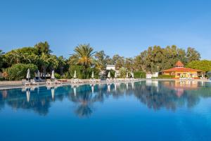 una gran piscina de agua con sillas y árboles en Green Max Hotel en Belek