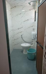 a bathroom with a toilet and a stone wall at StarNexa Residency in Navi Mumbai