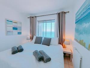 a bedroom with a white bed with two pillows on it at Bay Views in Simonʼs Town