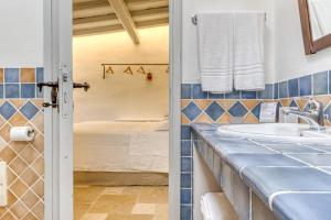baño con lavabo y cama en BioMasseria Santa Lucia en Alessano