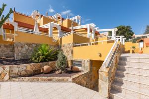 a yellow building with stairs in front of it at Apartamentos Punta Marina by LIVVO in Morro del Jable