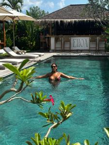 a woman in a swimming pool at a resort at EHOA BALI Nyanyi Boutique Hotel - In front of entrance to NUANU in Tanah Lot