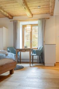 1 dormitorio con mesa, sillas y ventana en Chesa-Strimer - Studio, en La Punt-Chamues-ch