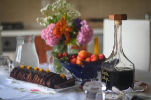 a table with a bottle of wine and a bowl of fruit at Apartman Rendulić in Ogulin