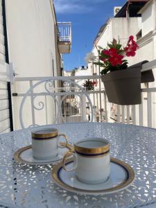 2 tasses à café assises sur une table sur un balcon dans l'établissement Maggie ‘s home, à Castellana Grotte