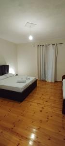 1 dormitorio con 1 cama y suelo de madera en Ο ΚΉΠΟΣ ΤΟΥ ΟΔΥΣΣΈΑ, en Xarrë