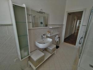 a white bathroom with a sink and a shower at Agriturismo Poggio Rotondo in San Gimignano