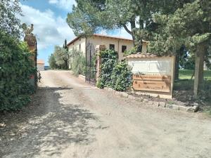 a house with a gate on a dirt road at Agriturismo Poggio Rotondo in San Gimignano