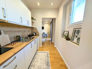 a kitchen with white cabinets and a sink and a window at Villa with Garden & Balcony in Berat