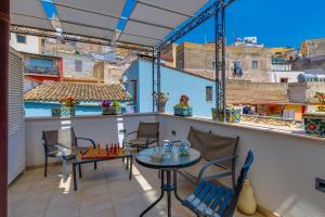 un patio avec une table et des chaises sur un balcon dans l'établissement La Finestra sul Cortile B&B, à Sciacca