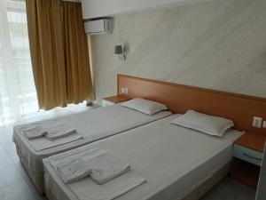 1 dormitorio con 2 camas con sábanas blancas y ventana en Sol e Mar, en Sunny Beach 1 foto más