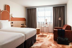 a hotel room with a bed and a chair at Pullman Paris Centre - Bercy in Paris