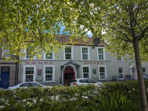 un hotel bianco con auto parcheggiate di fronte di Emmet Hotel a Clonakilty