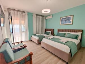 a bedroom with two beds and a chair in it at Rooftop Florale in Velipojë