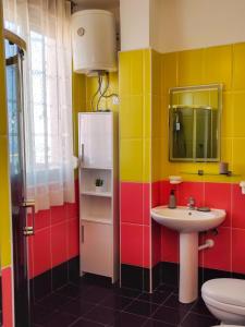 La salle de bains colorée est pourvue d'un lavabo et de toilettes. dans l'établissement Rooftop Florale, à Velipojë