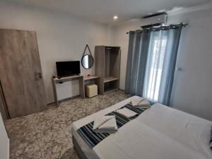 a bedroom with a large bed and a television at Venus De Milo in Adamas
