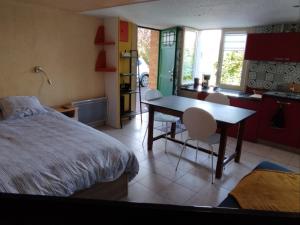 a bedroom with a bed and a table and chairs at Accueil curistes et Thermes climatisé in Montrond-les-Bains
