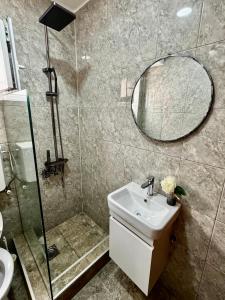 ein Badezimmer mit Waschbecken, Dusche und Spiegel in der Unterkunft Lajla Apartments in Dobra Voda