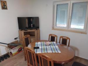 a table and chairs with a table and a tv at Visočka Banja Apartmani in Arilje