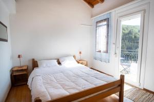 a bedroom with a large bed and a window at Billy's Stonehouse in Samos