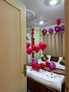 Habitación con globos rojos y morados en una cama en Heritage Rose Inn en Srinagar