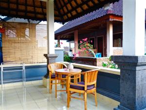 einen Tisch und Stühle auf einer Veranda mit einem Haus in der Unterkunft Kabera Bungalow 3 in Ubud