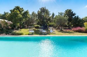 a group of chairs sitting next to a swimming pool at HELLO APULIA, Trulli Santa Maria dei Grani - with private pool and large garden for furry friends in Ceglie Messapica