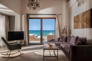 een woonkamer met een bank en uitzicht op de oceaan bij Kavo Seaside Luxury Apartment in Argassi