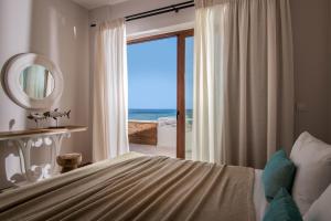 a bedroom with a bed with a view of the ocean at Kavo Seaside Luxury Apartment in Argasi