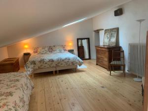 a bedroom with a bed and a dresser and a chair at Les Jardins d'Ayaël in Ozenay