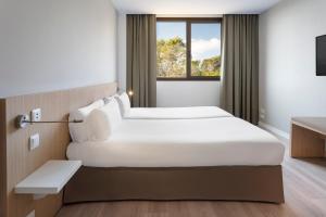 a hotel room with two beds and a window at B&B HOTEL Barcelona Sant Cugat in Sant Cugat del Vallès