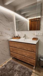 ein Badezimmer mit Waschbecken und Spiegel in der Unterkunft Vivienda vacacional El Cau - Casas de Los Picos in Ruenes